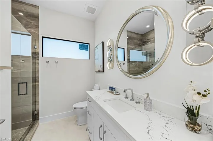 Full bath featuring vanity, a shower stall, and light tile patterned floors - Virtually Edited Image