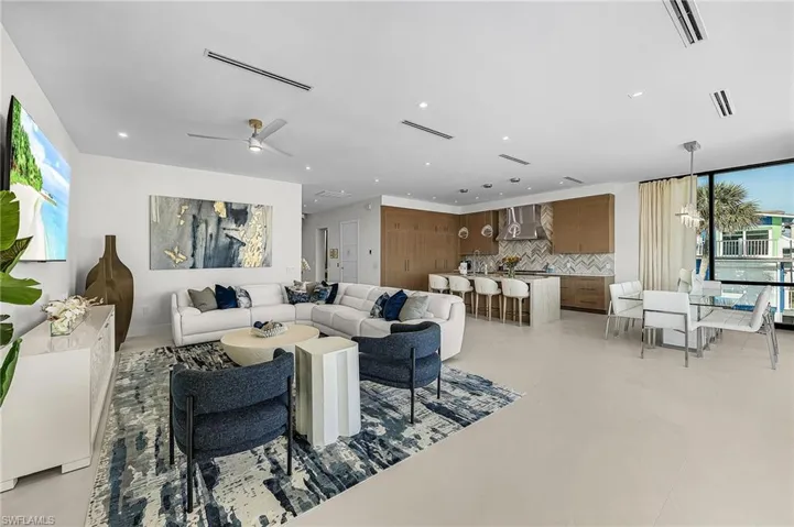 Living room with healthy amount of natural light, recessed lighting, and ceiling fan - Virtually Edited Image