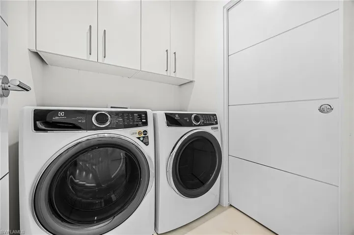Laundry room with washer and clothes dryer and cabinet space - Virtually Edited Image