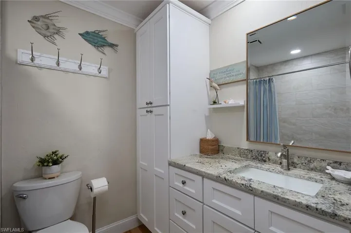 Bathroom with vanity, a shower with shower curtain, and crown molding