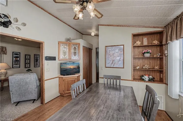 Dining space featuring a ceiling fan, light wood finished floors, and lofted ceiling