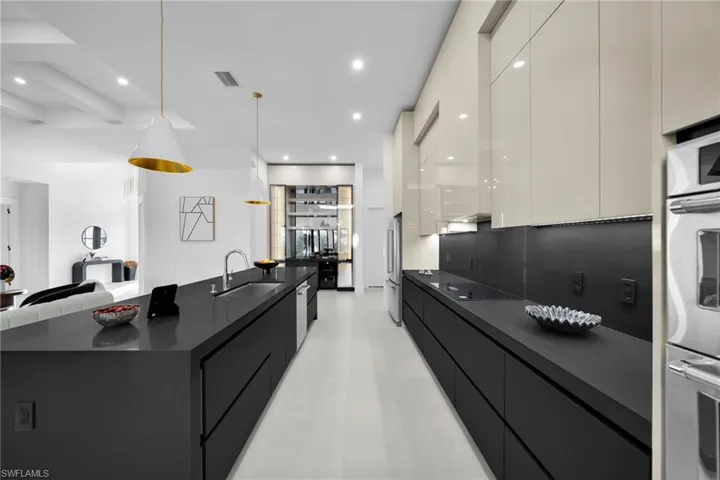 Kitchen with modern cabinets, hanging light fixtures, appliances with stainless steel finishes, recessed lighting, and a spacious island