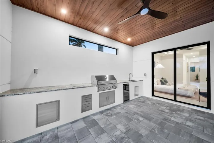 View of patio / terrace with an outdoor kitchen, a ceiling fan, and wine cooler