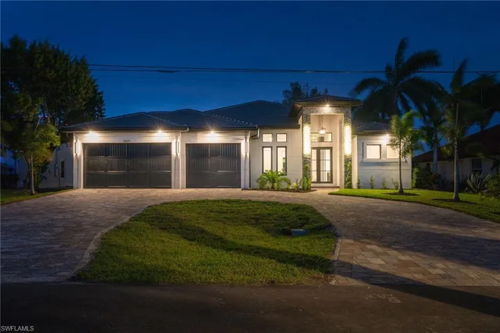 View of front of property featuring decorative driveway, a lawn, an attached garage, and stucco siding