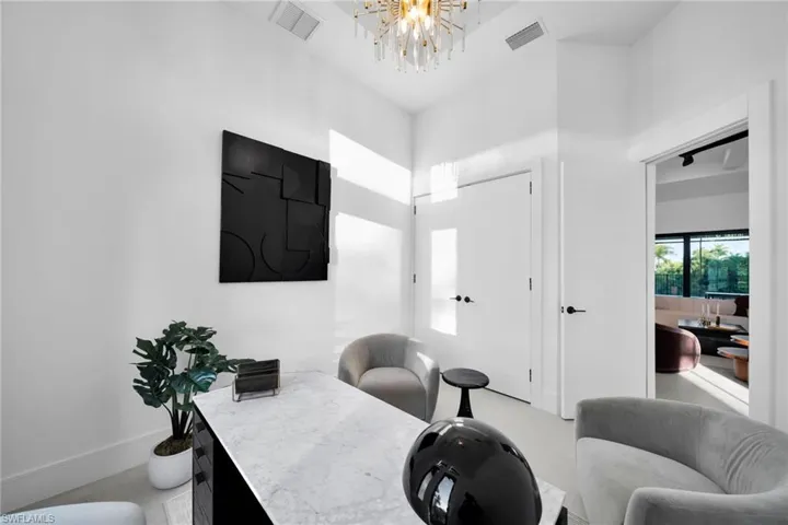 Office area featuring a chandelier and baseboards