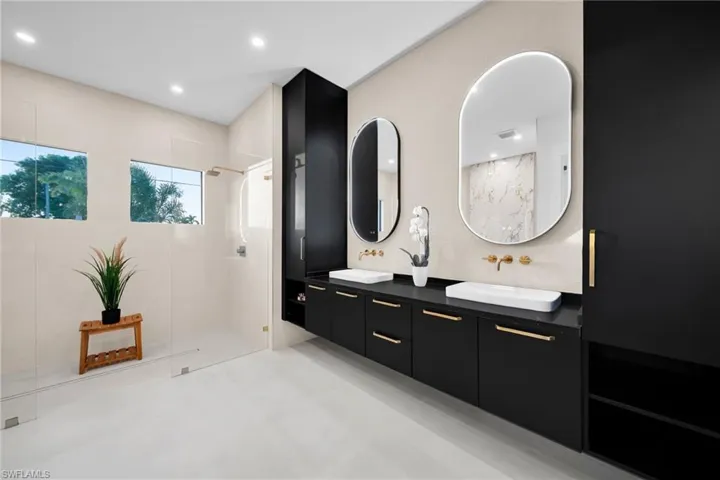 Bathroom with double vanity, a walk in shower, and recessed lighting