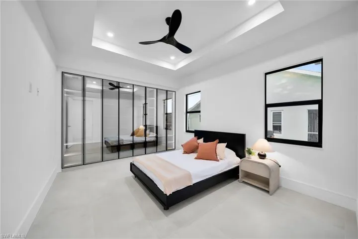 Bedroom featuring a raised ceiling, ceiling fan, recessed lighting, and a closet