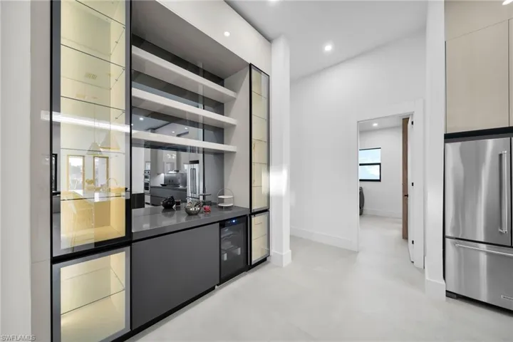 Bar with high quality fridge, open shelves, recessed lighting, wine cooler, and dark countertops