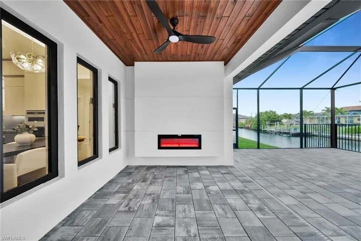View of patio featuring a sunroom, a water view, a ceiling fan, and a lanai