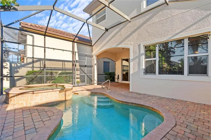View of pool with an in ground hot tub, a patio area, and a lanai