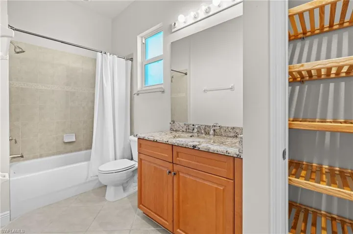 Full bathroom featuring tile patterned floors, vanity, toilet, and shower / tub combo