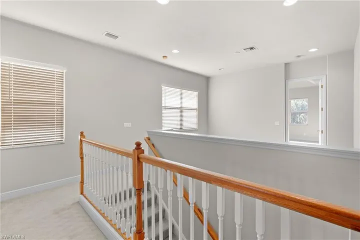 Hallway featuring light carpet