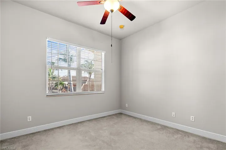 Empty room featuring ceiling fan and light colored carpet