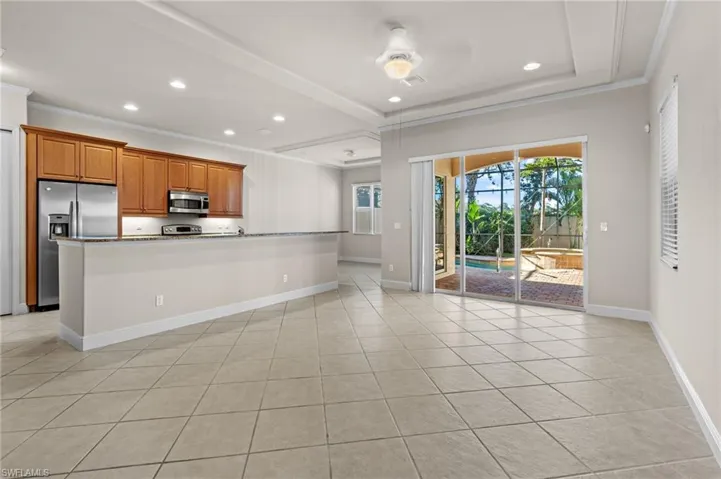 Kitchen with ceiling fan, ornamental molding, and appliances with stainless steel finishes