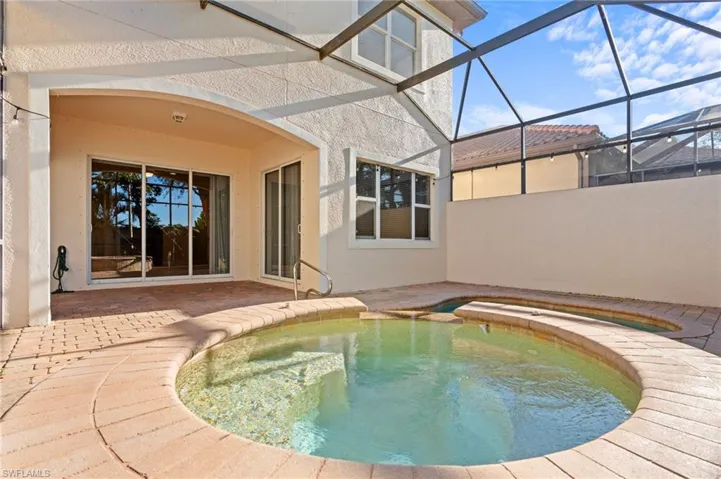 View of swimming pool featuring a patio and glass enclosure