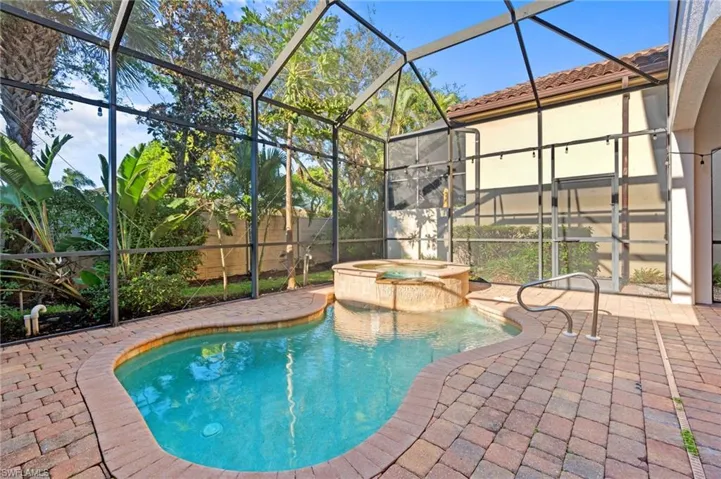 View of pool with a lanai, a patio area, and an in ground hot tub
