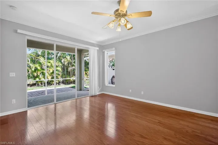 Empty room featuring crown molding, ceiling fan, and hardwood / wood-style flooring