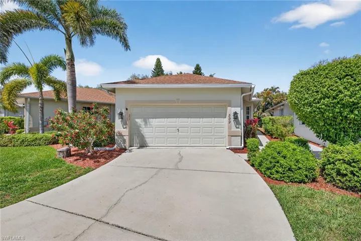 Single story home featuring concrete driveway, an attached garage, stucco siding, and a front yard