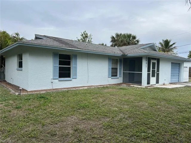 Back of house featuring a sunroom and a lawn