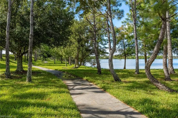View of property's community with a water view and a lawn