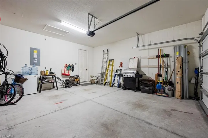 Garage featuring a garage door opener and electric panel
