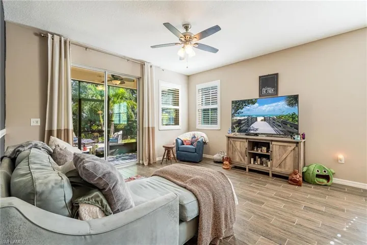 Living room featuring a textured ceiling, ceiling fan, and light hardwood / wood-style floors