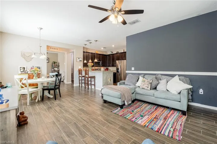Living room with ceiling fan and hardwood / wood-style flooring