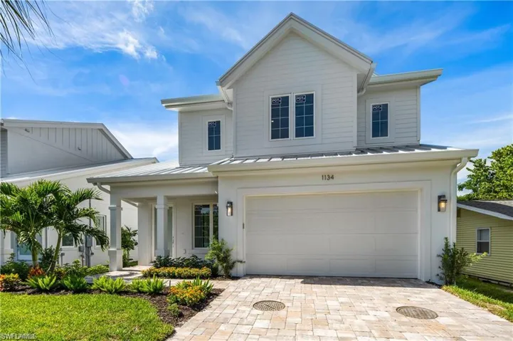 View of front of home featuring metal roof, decorative driveway, an attached garage, and a standing seam roof