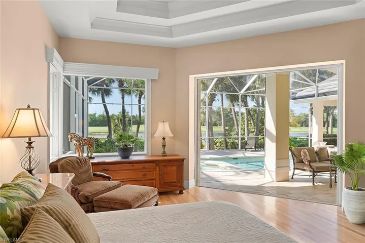Primary bedroom with stunning ceiling features brings outdoor living in with sunset and pool views