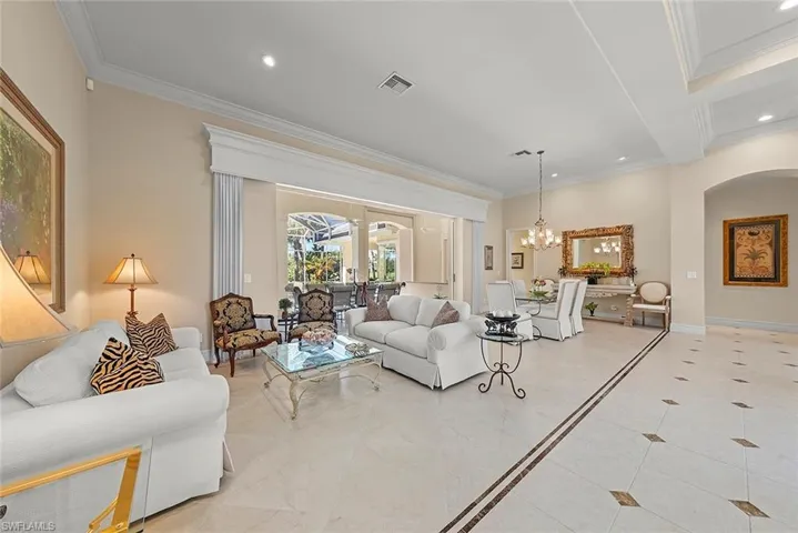 Elegant formal living & dining stuns with detailed, custom tile flooring & coffered ceiling