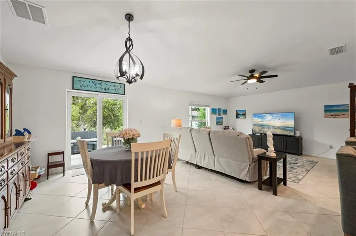Dining space featuring ceiling fan, a chandelier, and light tile patterned floors