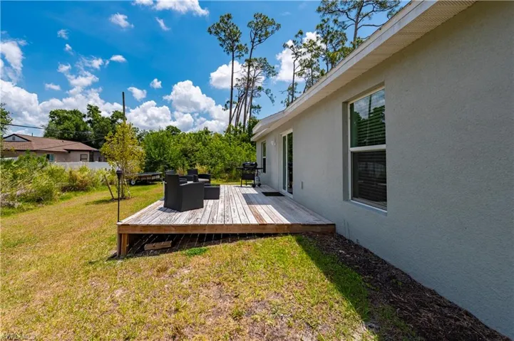 View of grassy yard featuring a deck