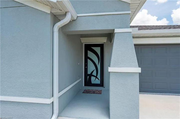 Doorway to property with stucco siding and an attached garage