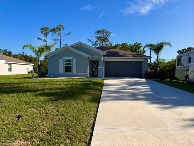 View of front of home featuring stucco siding, an attached garage, driveway, and a front lawn