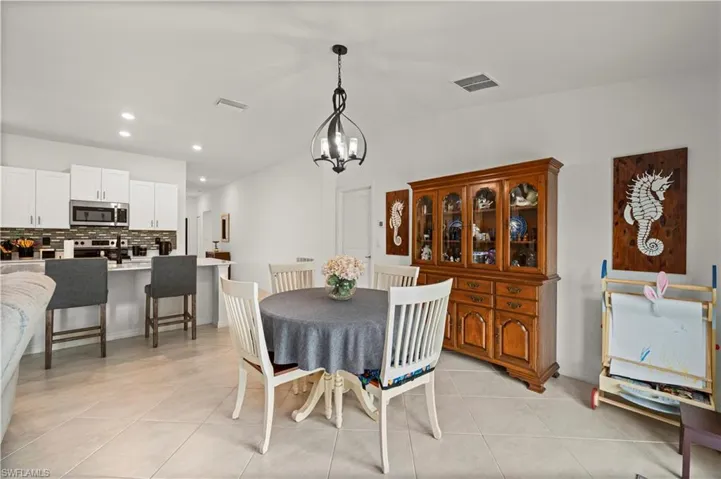 Dining area with a chandelier, light tile patterned floors, and recessed lighting