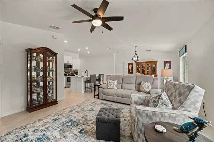 Living area featuring ceiling fan, light tile patterned flooring, recessed lighting, and lofted ceiling