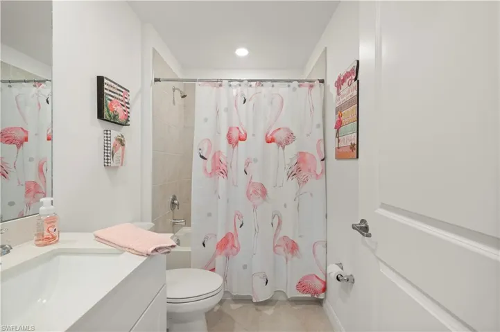 Bathroom with vanity, shower / bathtub combination with curtain, tile patterned floors, and recessed lighting