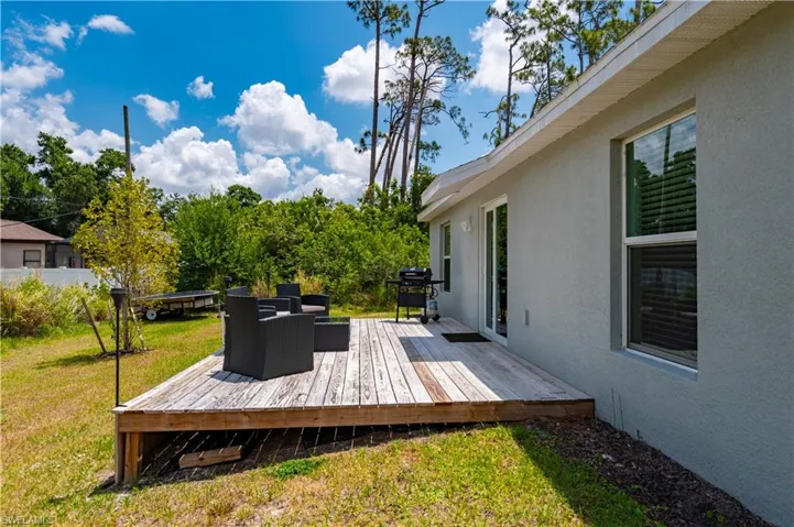 Wooden terrace with area for grilling and a lawn