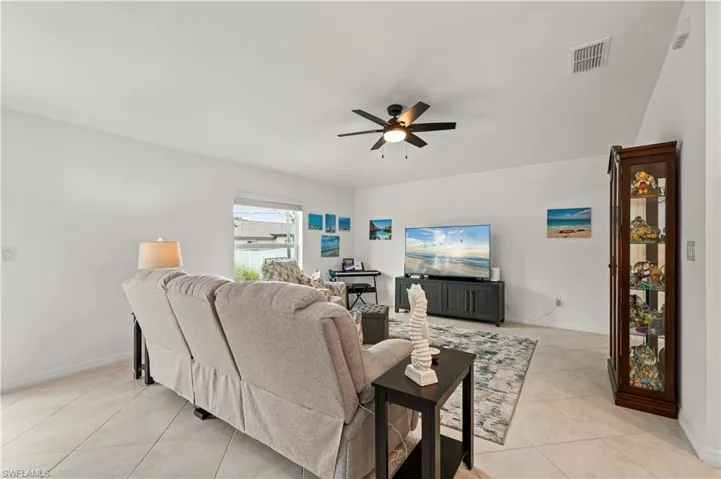 Living room featuring a ceiling fan and light tile patterned floors