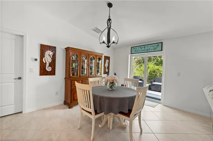 Dining space featuring a chandelier, lofted ceiling, and light tile patterned floors
