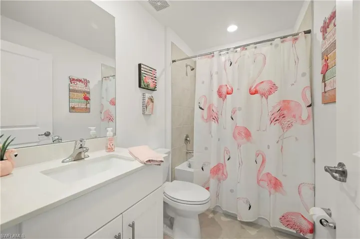 Bathroom with vanity, shower / bath combination with curtain, tile patterned floors, and recessed lighting