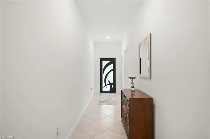 Hall with light tile patterned floors and recessed lighting
