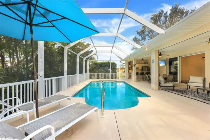 View of swimming pool with a patio, ceiling fan, and a lanai