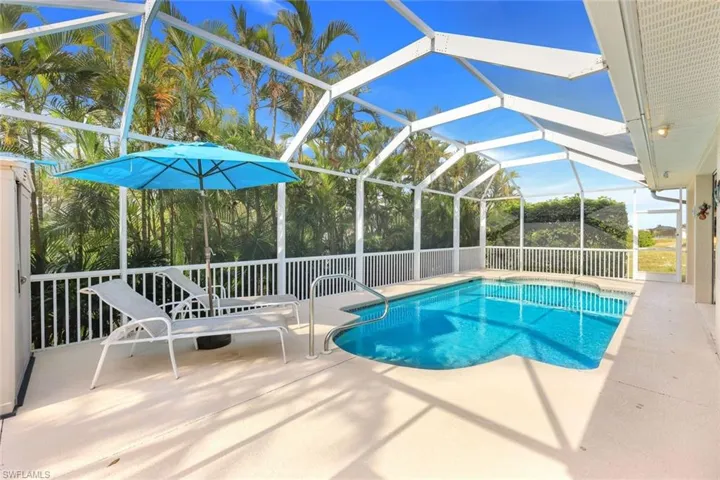 View of pool featuring a patio and glass enclosure