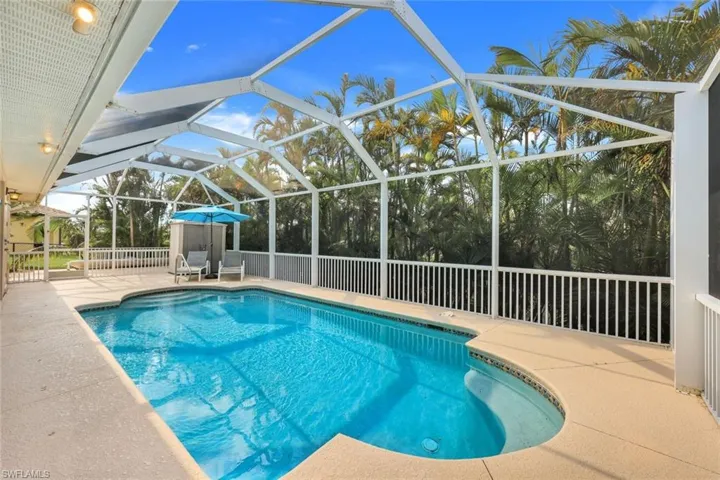 View of swimming pool with a patio area and glass enclosure