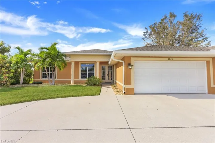 Ranch-style home with a front yard and a garage
