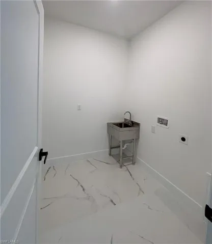 Laundry area with marble finish flooring, washer hookup, and electric dryer hookup
