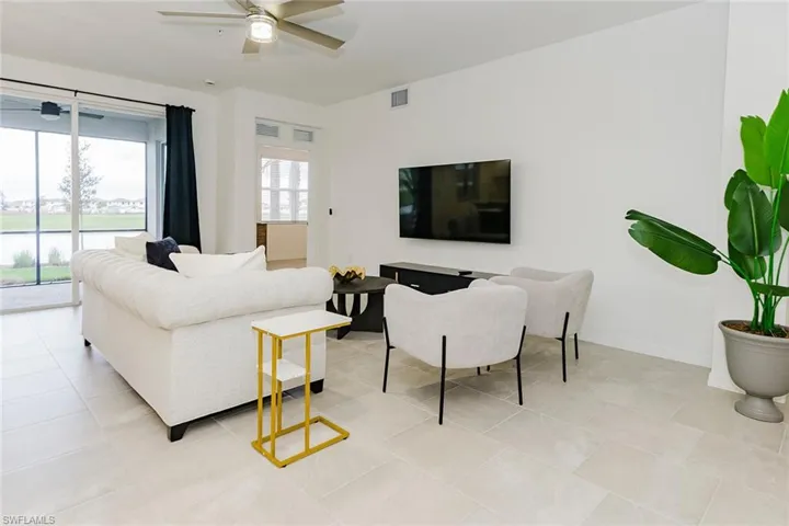 Living room with a ceiling fan and light tile patterned floors