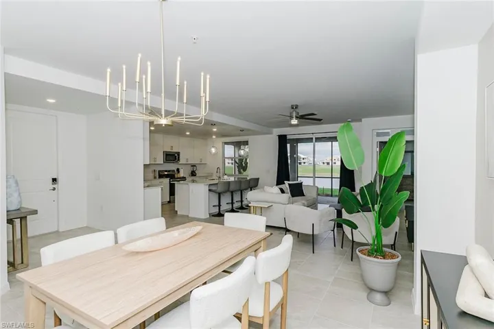 Dining space featuring a ceiling fan, a chandelier, and light tile patterned floors