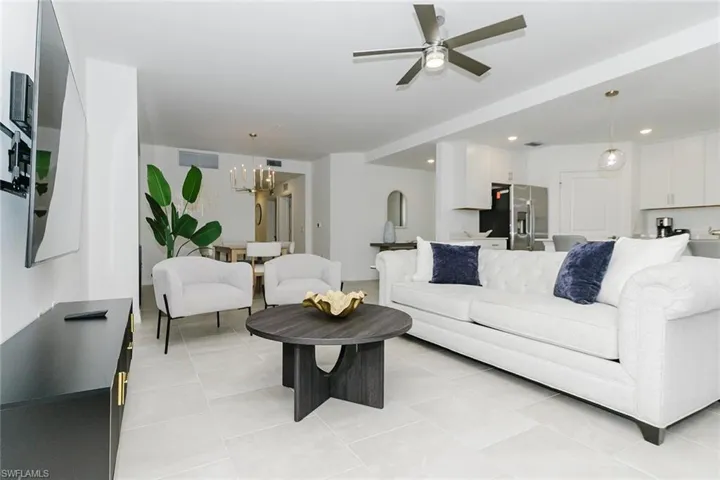 Living room featuring ceiling fan, hanging lights, and light tile patterned flooring